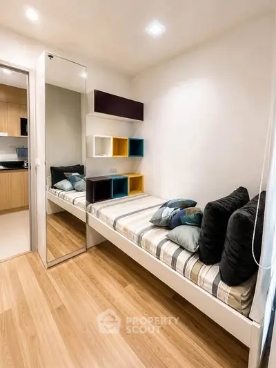 Modern bedroom with stylish shelving and cozy bed in contemporary apartment.