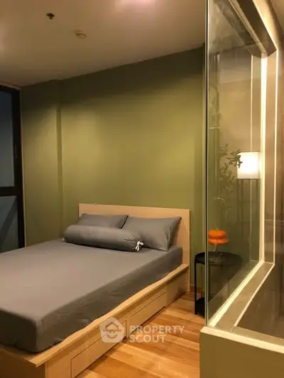 Cozy bedroom with modern design and glass partition, featuring a comfortable bed and stylish decor.