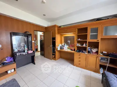 Spacious study room with wooden built-in shelves and tiled flooring