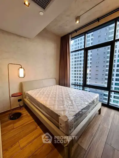 Modern bedroom with large window and stylish lighting in urban apartment