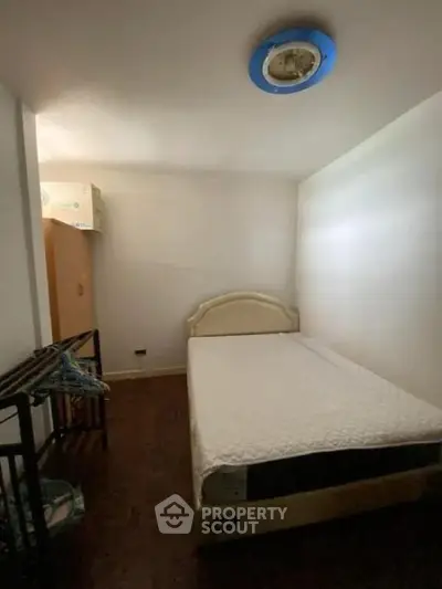 Cozy bedroom with minimalist design and essential furnishings for comfortable living.