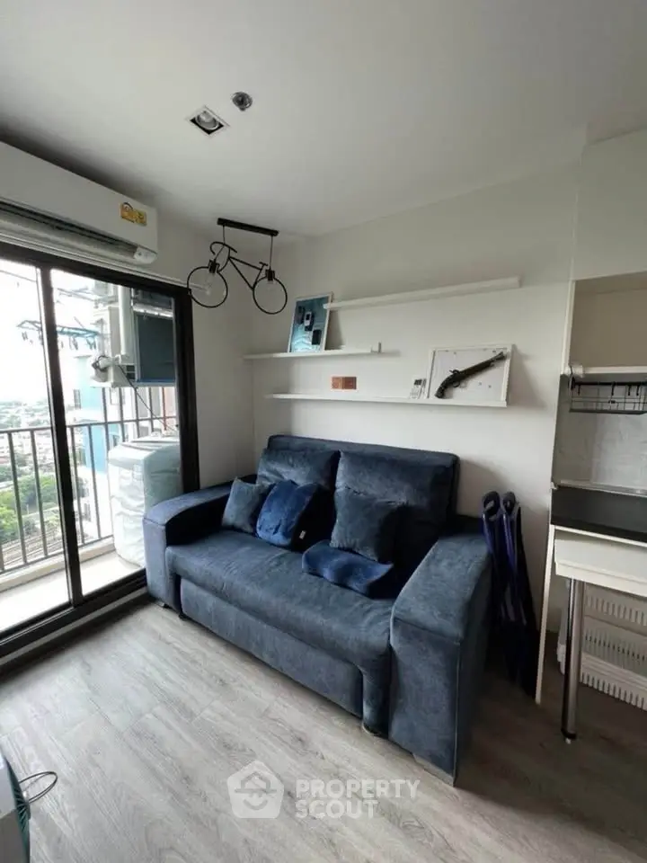Cozy living room with blue sofa and balcony view in modern apartment