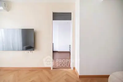 Modern living room with wall-mounted TV and wooden flooring