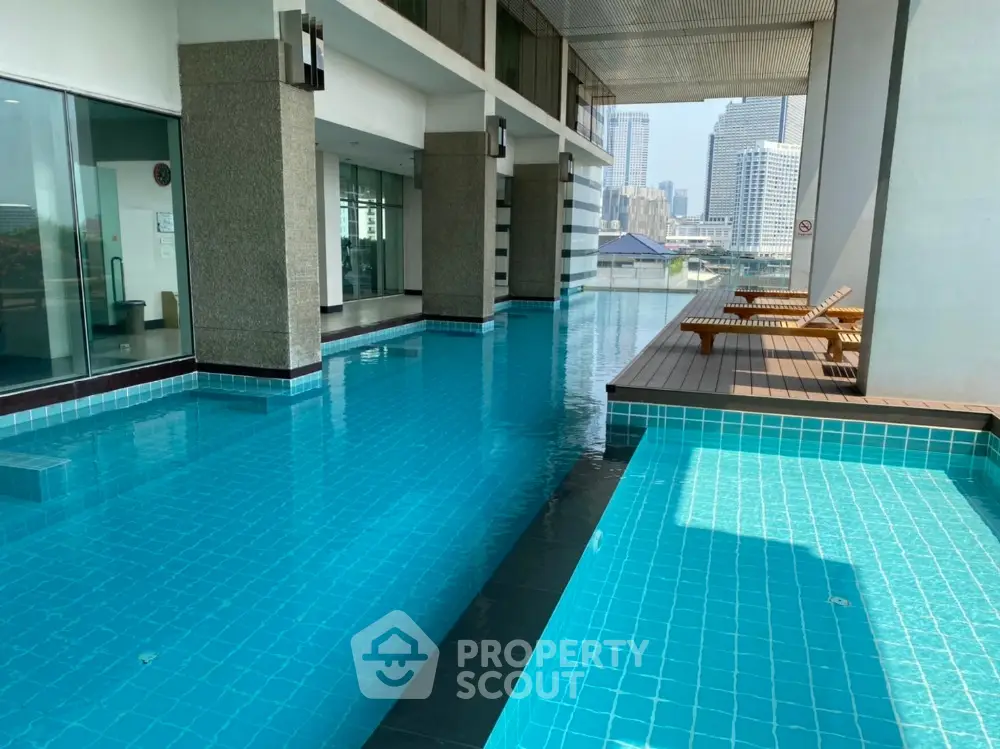 Luxurious high-rise pool with city view and sun loungers, perfect for relaxation.