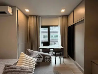Modern studio apartment with cozy living area and work desk by the window.