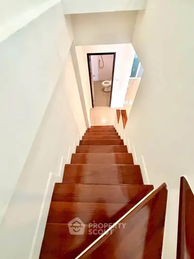 Modern staircase leading to a compact bathroom with sleek design