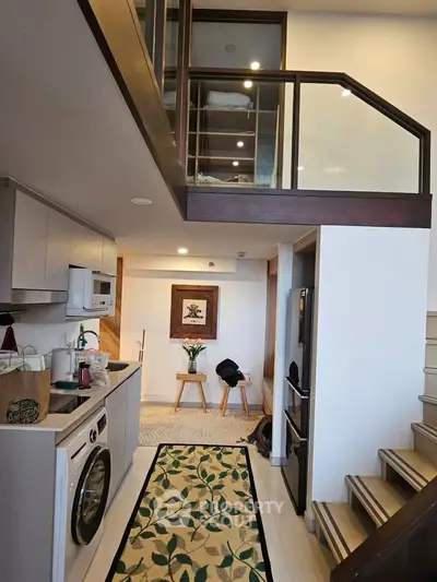 Modern loft apartment with stylish kitchen and mezzanine level, featuring sleek appliances and elegant decor.