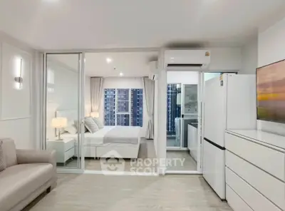 Modern open-plan apartment with sleek kitchen and spacious bedroom, featuring large windows and contemporary decor.