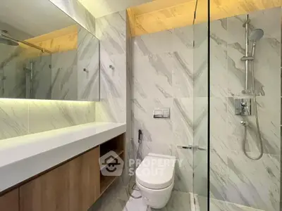 Modern bathroom with sleek design, featuring a glass shower and elegant marble tiles.