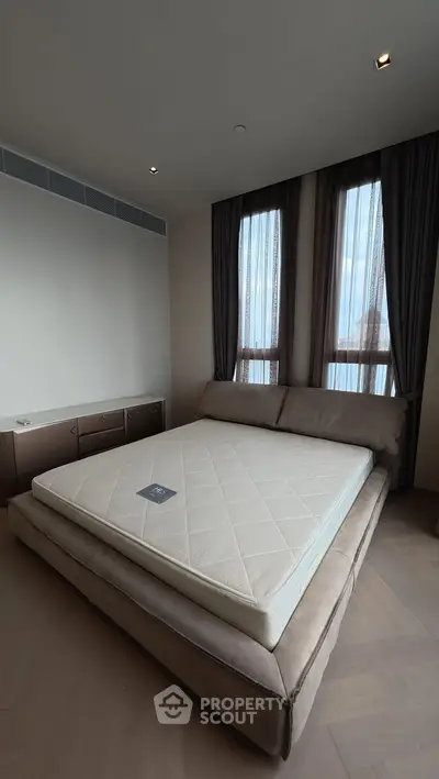 Luxurious bedroom with elegant bed and large windows offering natural light.