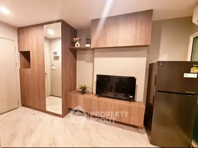 Modern living room with sleek wooden cabinetry and stainless steel fridge