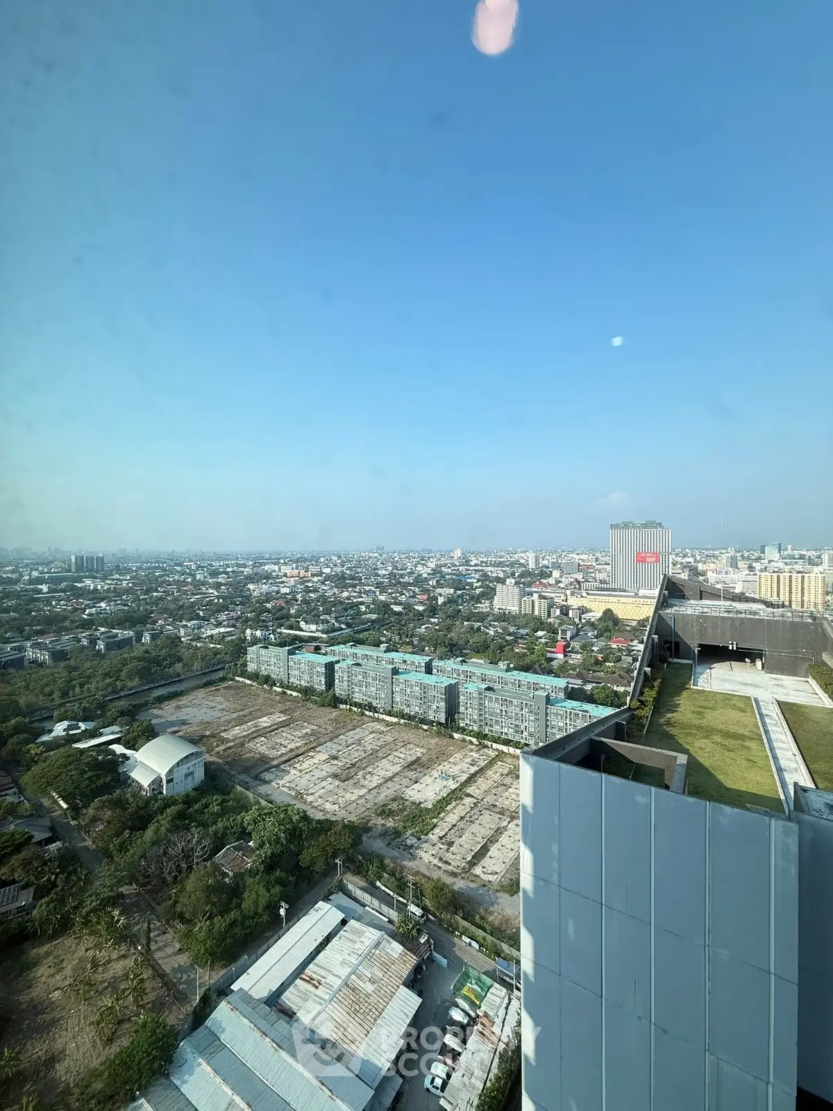 Stunning cityscape view from high-rise building with expansive skyline and lush greenery.