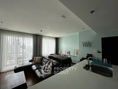 Spacious modern living room with city view and open kitchen layout.