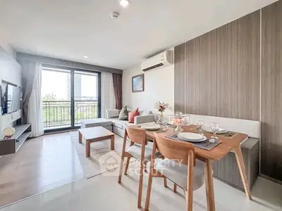 Modern living room with dining area and balcony view in a stylish apartment.