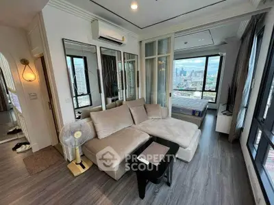 Modern living room with panoramic city view and cozy seating area.