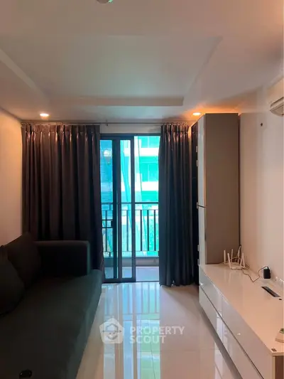 Modern living room with sleek furniture and balcony view in a stylish apartment.