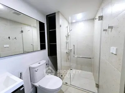 Modern bathroom with glass shower enclosure and sleek fixtures