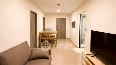 Modern living room with cozy sofa, dining area, and TV setup in a stylish apartment.