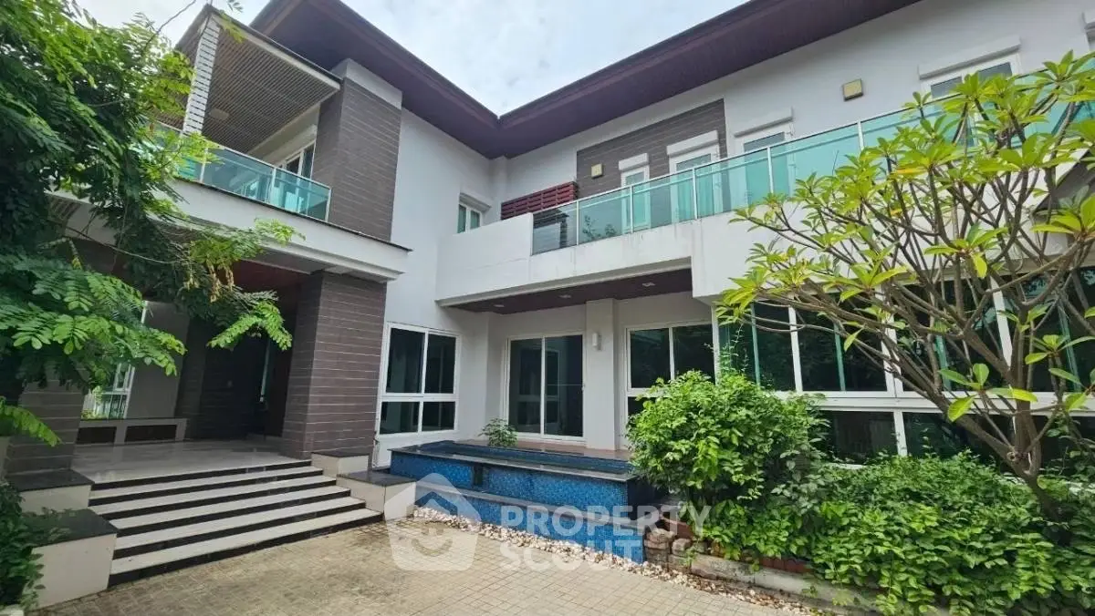 Luxurious modern home with spacious balcony and lush garden