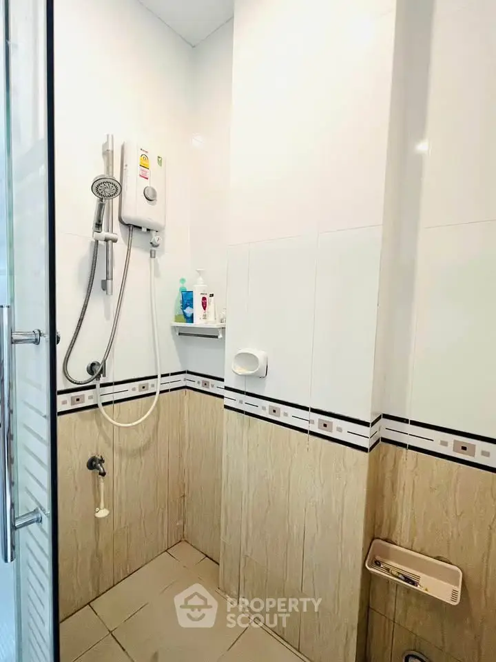 Modern bathroom with shower and tiled walls in a real estate property.