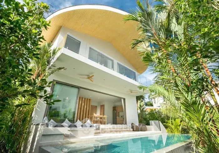 Luxurious modern villa with stunning pool and lush greenery, perfect for tropical living.