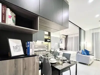 Modern open-plan living and dining area with sleek kitchen and cozy bedroom