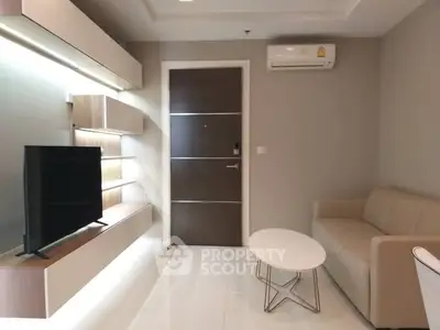 Modern living room with sleek furniture and mounted TV in a stylish apartment.