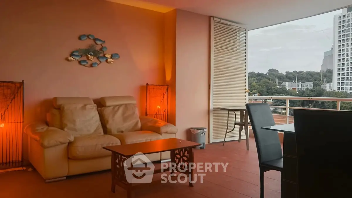 Spacious balcony with cozy seating and city view, perfect for relaxation.