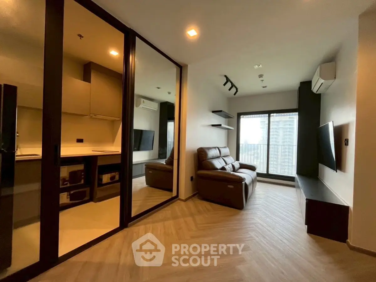 Modern living room with sleek design and city view, featuring cozy seating and large windows.