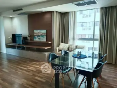 Spacious modern living room with dining area and large windows in a stylish apartment.
