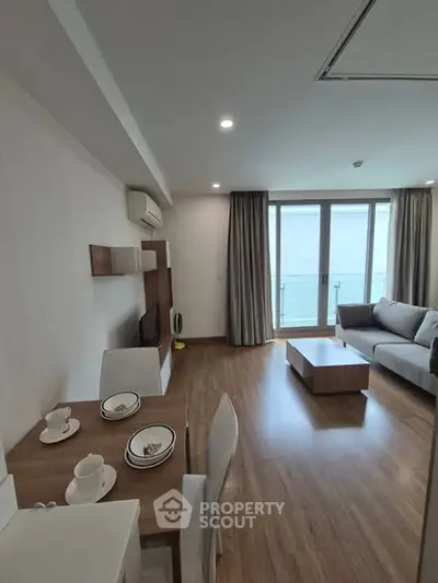 Modern living room with stylish furniture and balcony view, perfect for urban living.