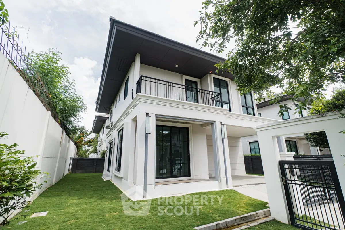 Modern two-story house with lush green lawn and sleek balcony design