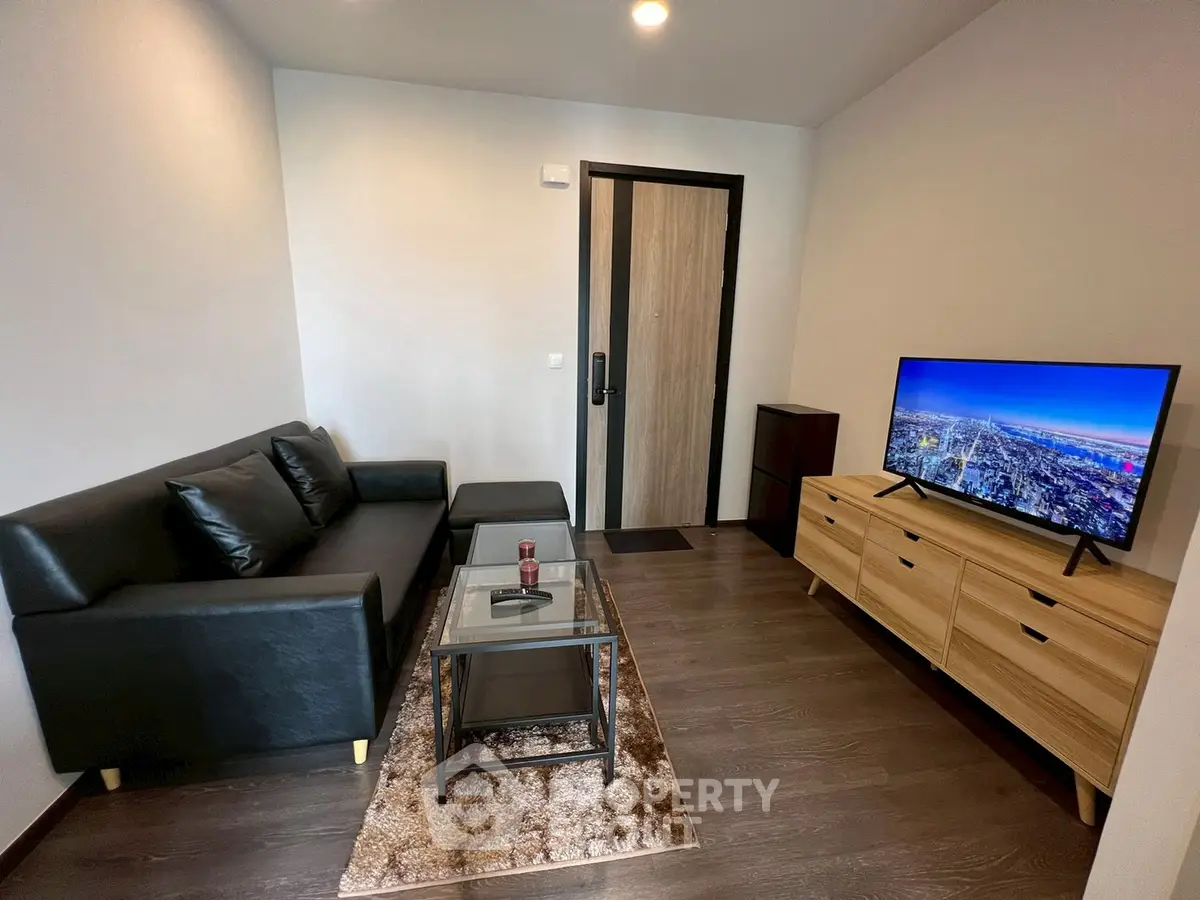 Modern living room with sleek black sofa and flat-screen TV