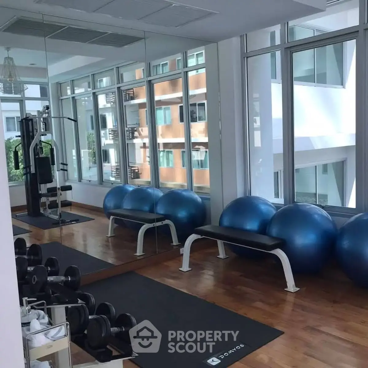 Modern gym with exercise equipment and large mirrors in a residential building.