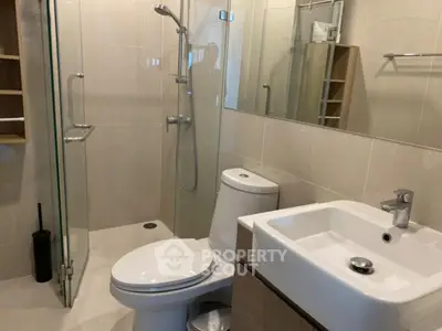 Modern bathroom with glass shower and sleek fixtures in a contemporary home.