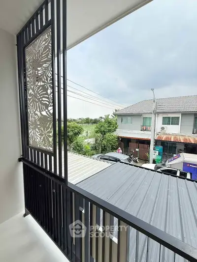 Modern balcony with decorative screen and neighborhood view
