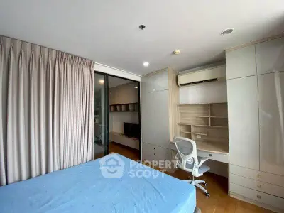 Modern bedroom with built-in desk and storage, featuring a comfortable bed and sleek design.