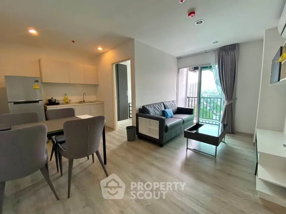 Modern living room with open kitchen and balcony view in stylish apartment