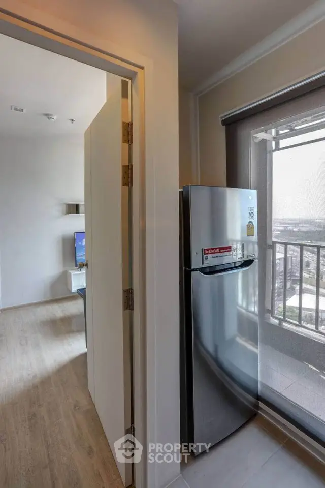 Modern apartment interior with sleek fridge and balcony view
