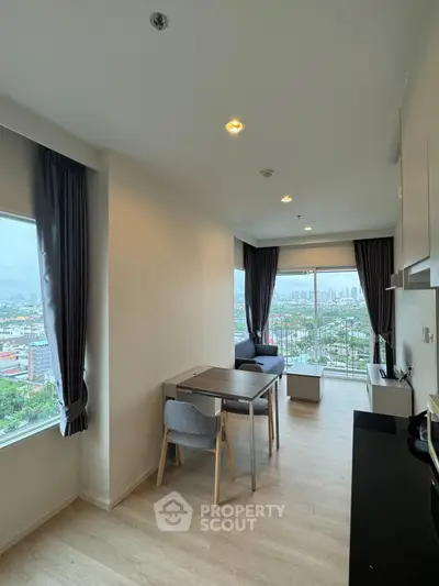 Modern apartment with open layout and stunning city view from large windows.