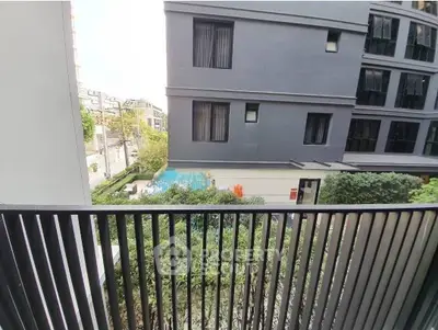 Modern apartment balcony with view of pool and urban landscape.