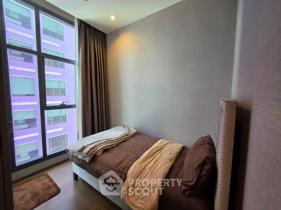 Cozy bedroom with large window and modern decor in urban apartment