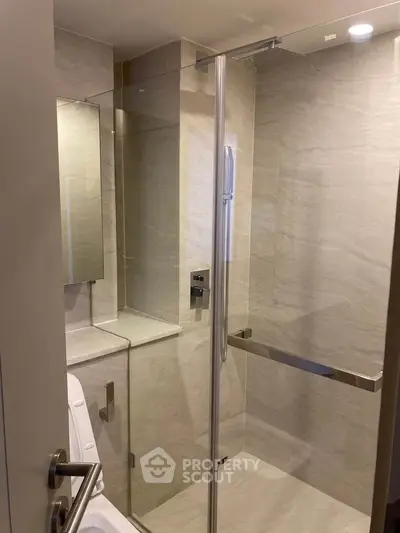 Modern bathroom with glass shower enclosure and sleek fixtures