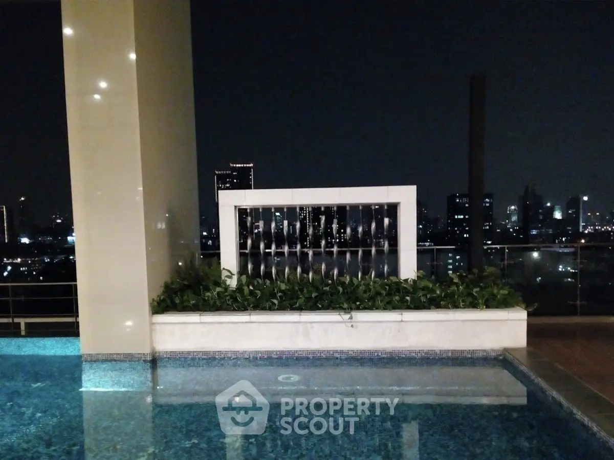 Luxurious rooftop pool with stunning city skyline view at night, perfect for relaxation and entertainment.