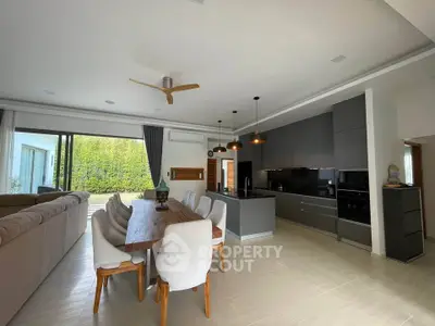 Spacious open-plan living and dining area with modern kitchen and garden view.