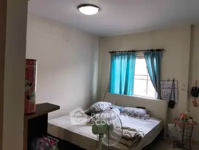 Cozy bedroom with natural light and simple decor, ideal for comfortable living.