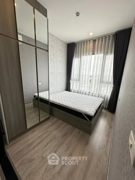 Modern bedroom with large mirror wardrobe and floor-to-ceiling windows