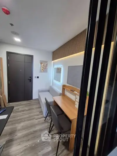 Modern study room with sleek desk and chairs, featuring stylish lighting and wood accents.