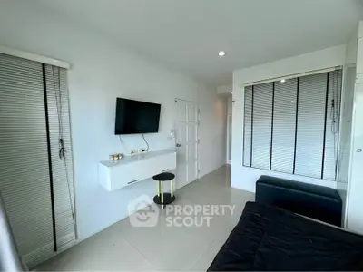 Modern bedroom with wall-mounted TV and sleek white decor