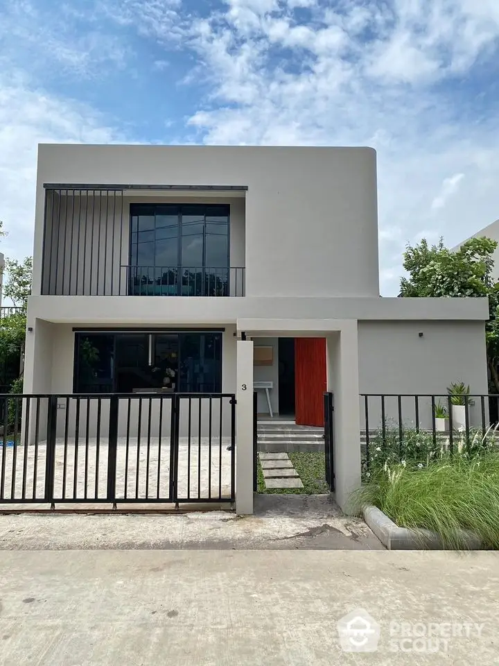 Modern minimalist two-story house with sleek facade and spacious driveway